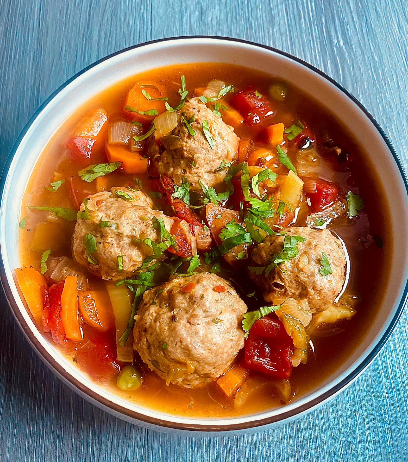Homemade lamb meatball soup with vegetables, fire-roasted tomatoes and fresh herbs